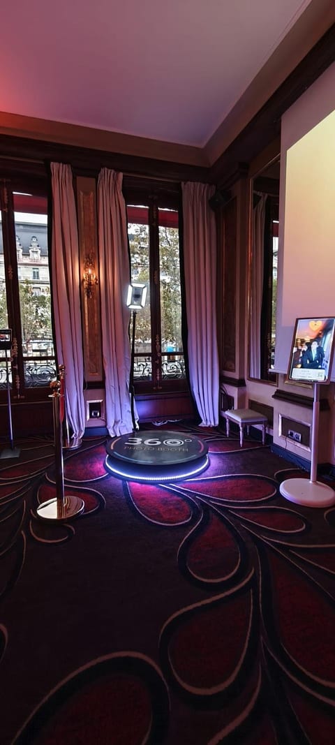 Vidéobooth 360° installé dans un salon du Fouquet's, potelets dorés et cordon rouge, écran des vidéos du gala à droite