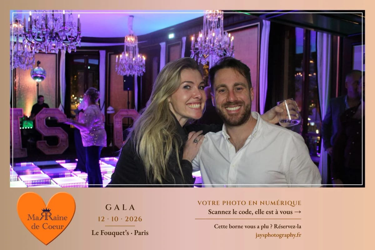 Deux invités du gala devant la borne photo, dans un salon du Fouquet's aux lumières violettes