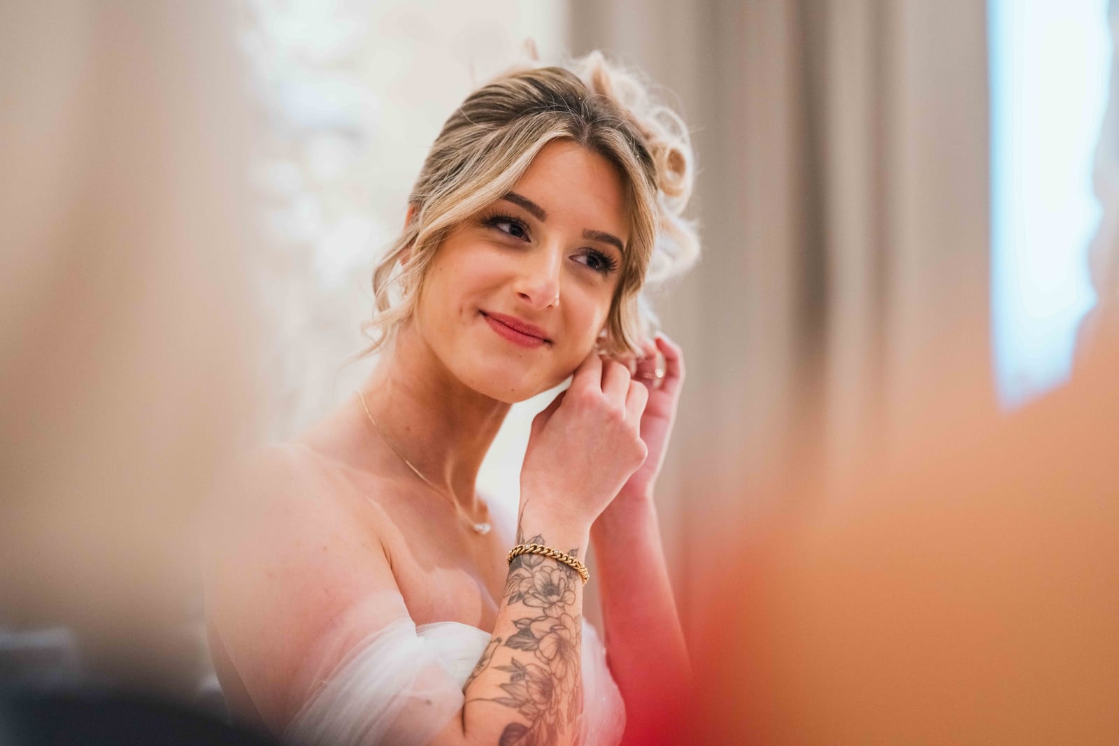 Alice en robe de mariée, portrait rapproché, main tatouée de fleurs posée contre la joue, mariage au Château de Pontarmé, par Jean-Baptiste Argyre (Jaysphotography)
