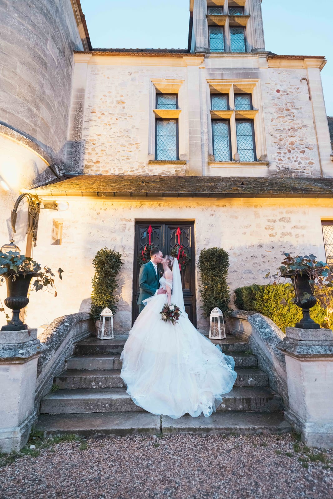 Alice et Allan sur les marches du château illuminé en heure bleue, lanternes blanches, mariage au Château de Pontarmé, par Jean-Baptiste Argyre (Jaysphotography)