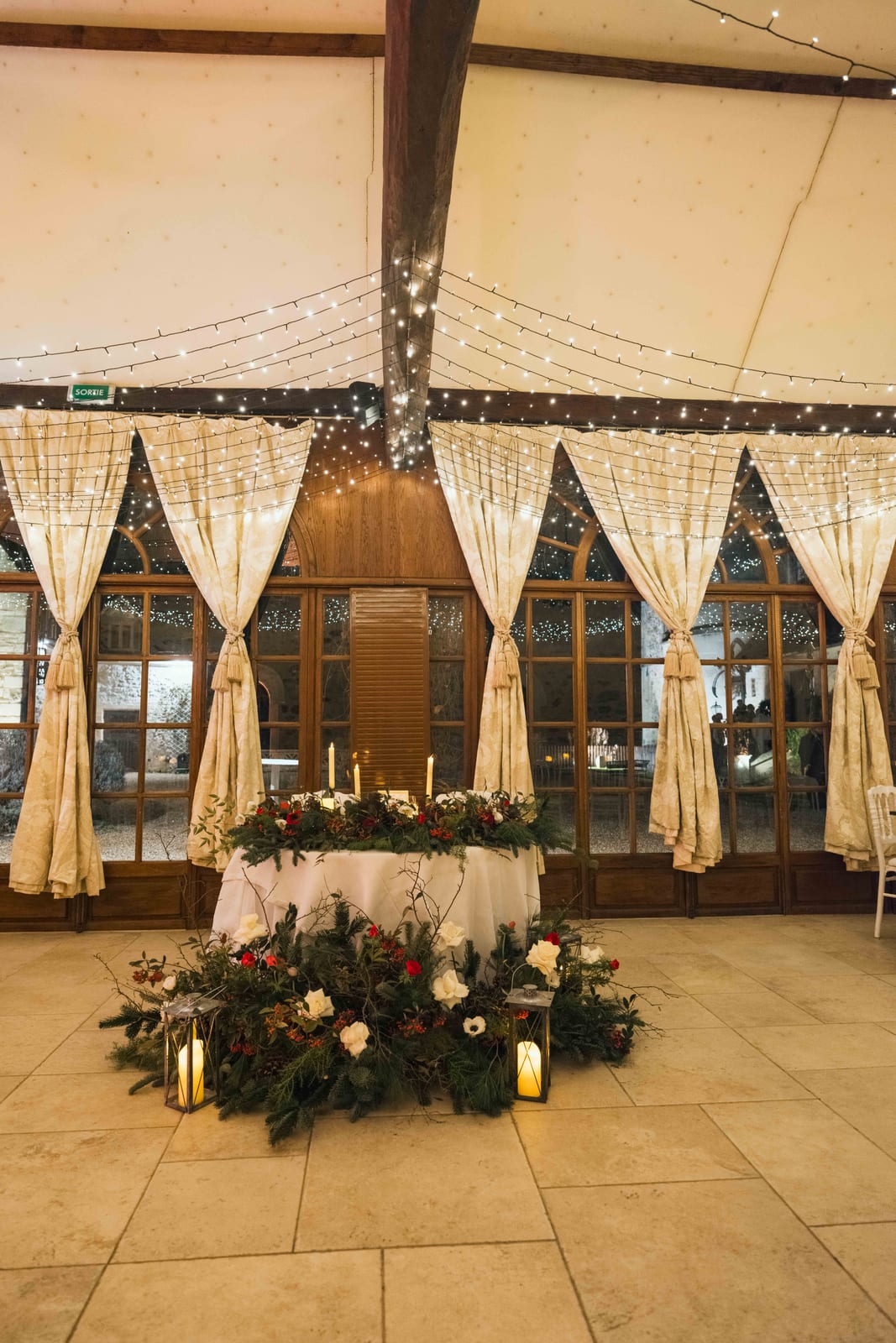 Table des mariés avec guirlandes lumineuses, verdure hivernale et bougies, mariage au Château de Pontarmé, par Jean-Baptiste Argyre (Jaysphotography)