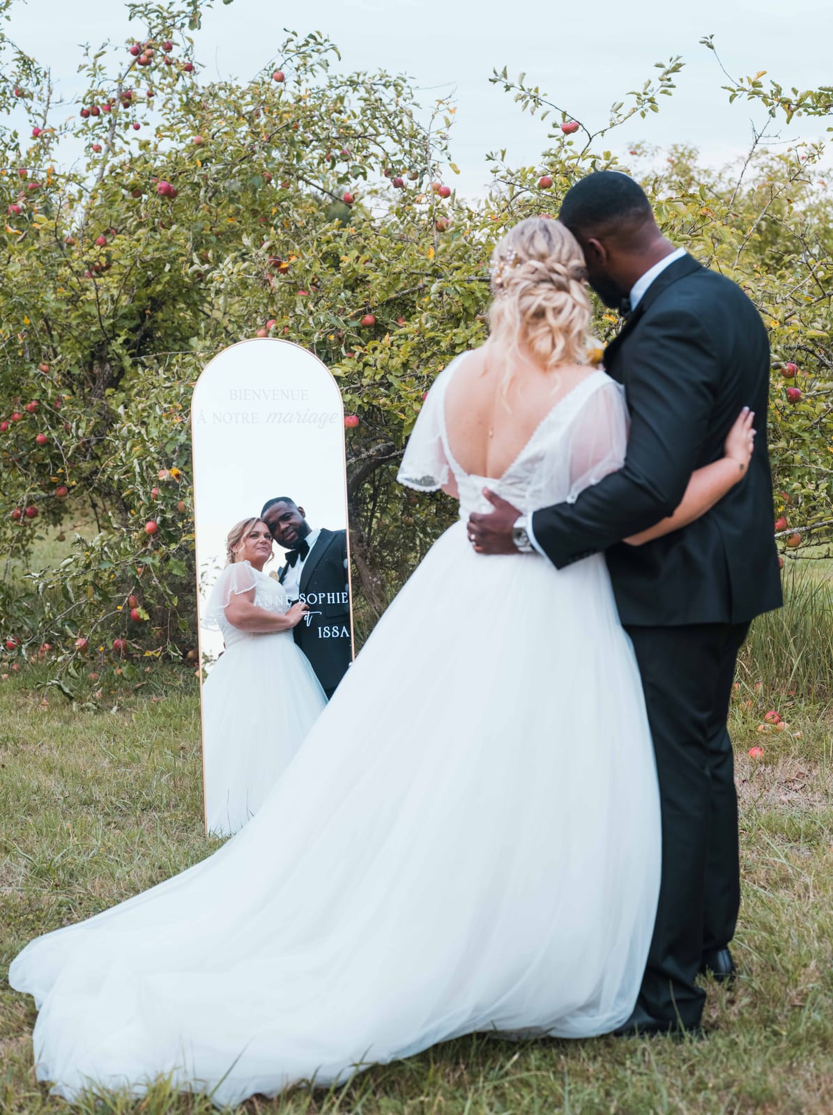 Le couple s'embrassant devant l'arche miroir en extérieur, reflet blanc et nature, moment complice, mariage au Domaine du Mont Rouge, par Jean-Baptiste Argyre (Jaysphotography)