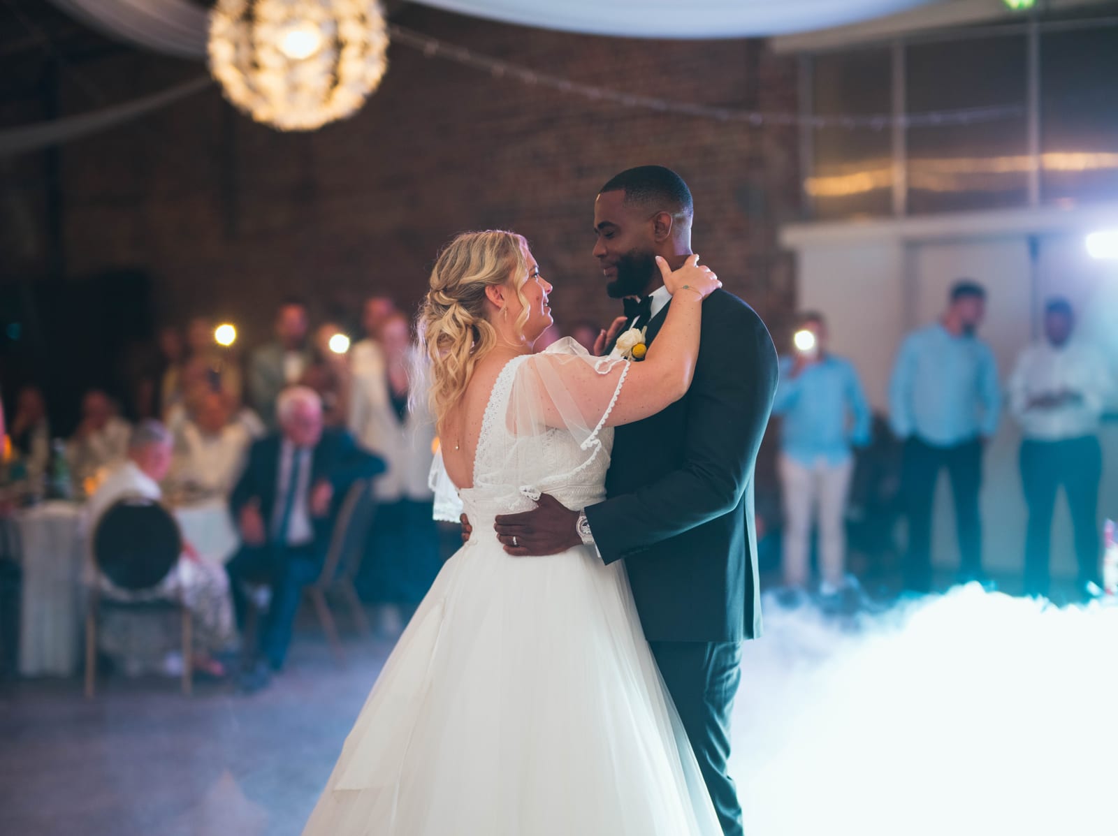 Anne-Sophie et Issa sur la piste de danse lors de la soirée, invités et lumières en arrière-plan festif, mariage au Domaine du Mont Rouge, par Jean-Baptiste Argyre (Jaysphotography)