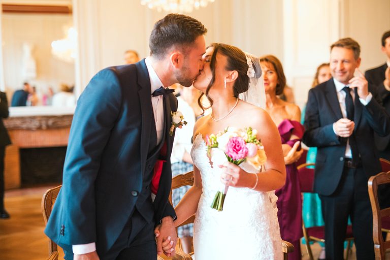 Le baiser des mariés sous les applaudissements dans la salle des mariages