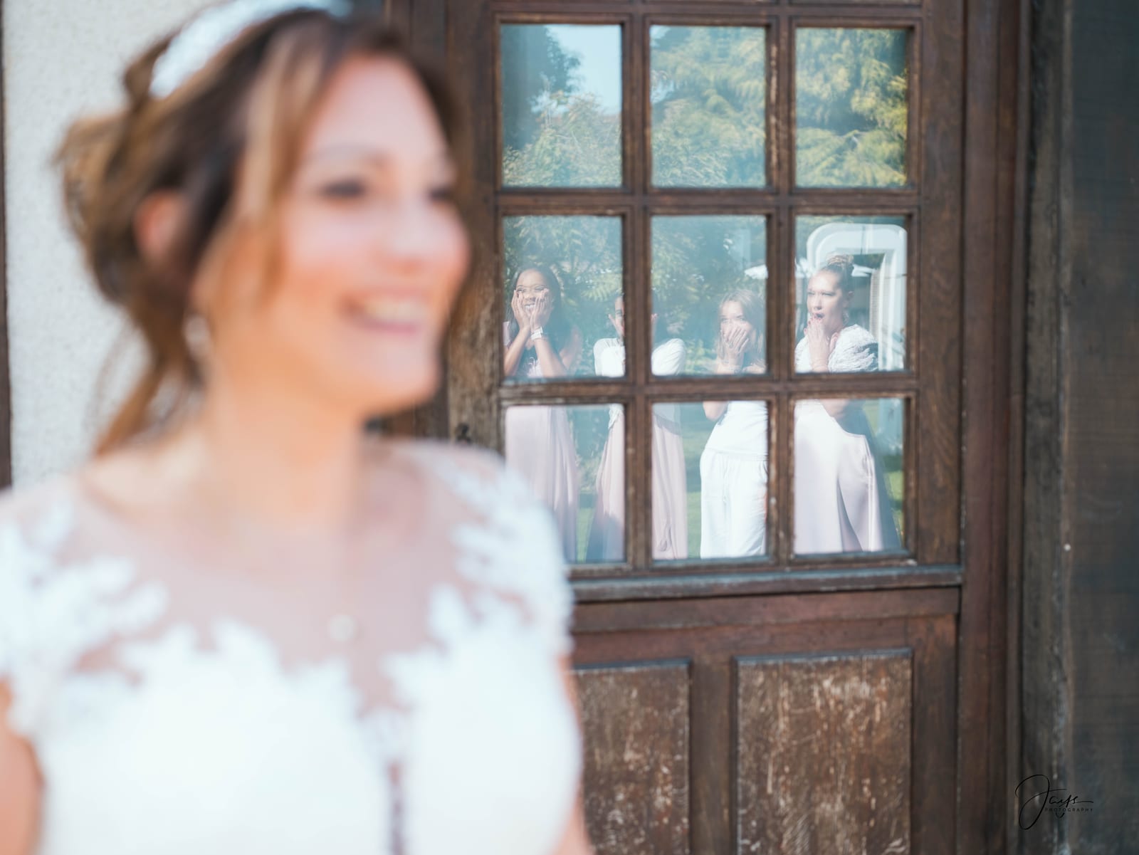 Portrait de Christelle souriante devant de grandes portes en bois sombre, le jour de son mariage, photo Jaysphotography., mariage au Domaine de la Croix Sauvalle, par Jean-Baptiste Argyre (Jaysphotography)