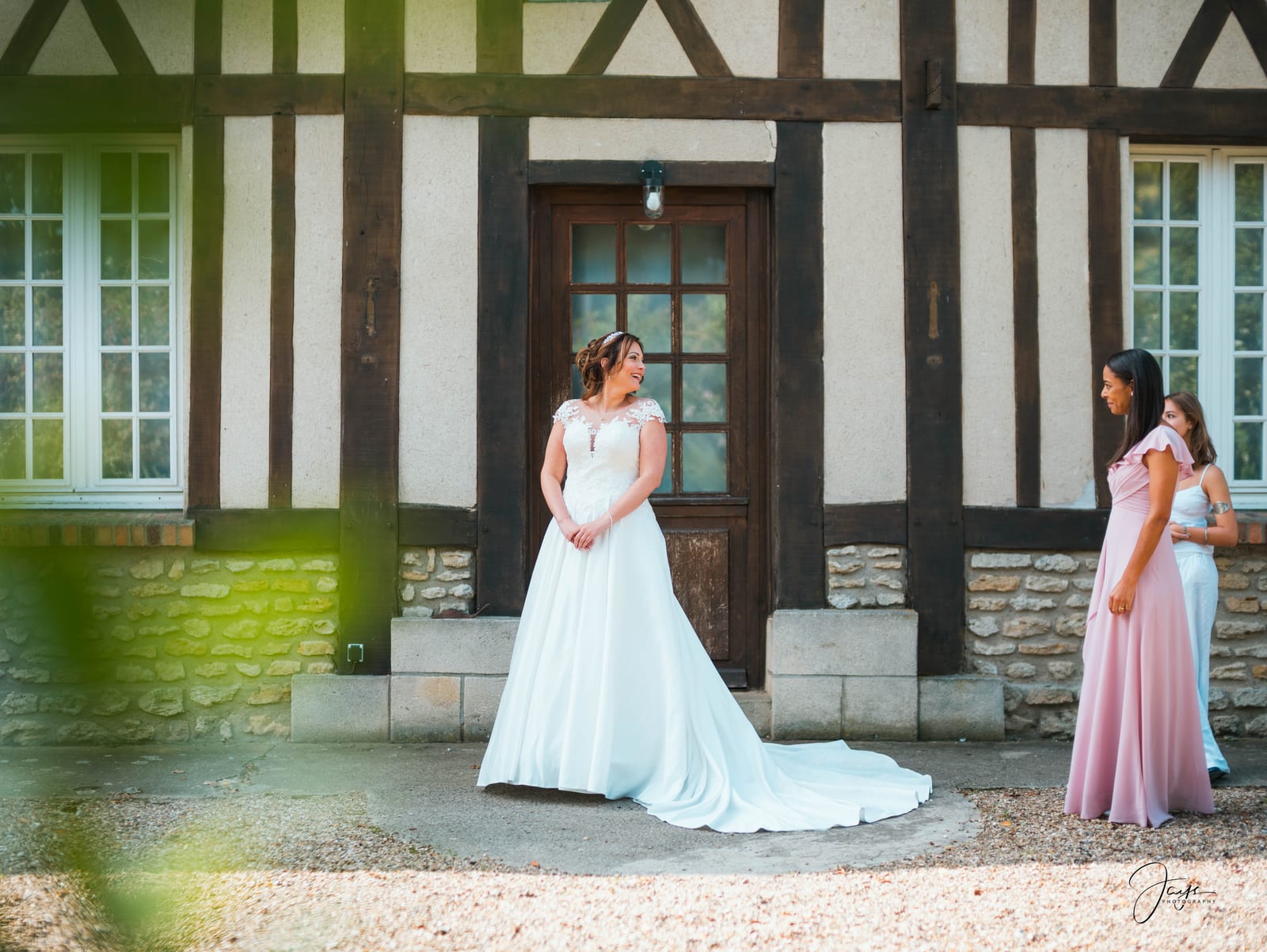 Christelle en robe blanche devant le bâtiment à colombages du Domaine de la Croix Sauvalle, photo Jaysphotography., mariage au Domaine de la Croix Sauvalle, par Jean-Baptiste Argyre (Jaysphotography)