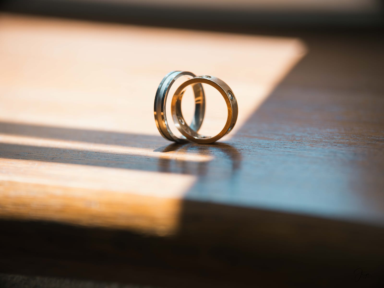 Alliances posées sur un coussin doré, détail bijoux du mariage d'Eugénie et Vincent, mariage au Domaine de la Fauconnie, par Jean-Baptiste Argyre (Jaysphotography)