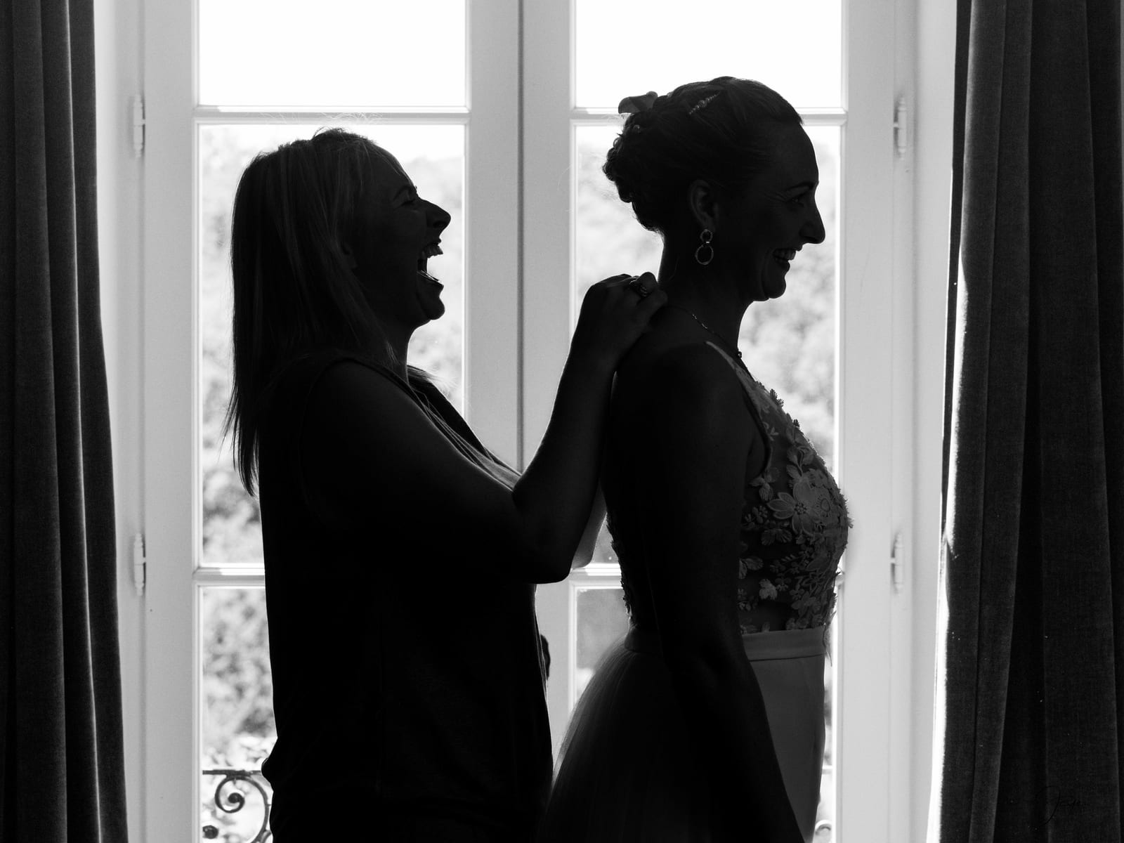 Silhouettes d'Eugénie et Vincent en contre-jour dans la verrière de réception, mariage au Domaine de la Fauconnie, par Jean-Baptiste Argyre (Jaysphotography)
