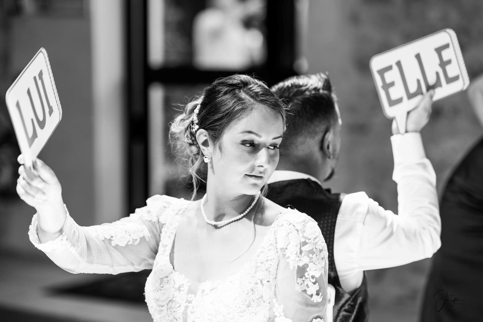 Mariée tenant les pancartes LUI et ELLE, jeu animé lors de la soirée, mariage au Ferme de Maubuisson, par Jean-Baptiste Argyre (Jaysphotography)