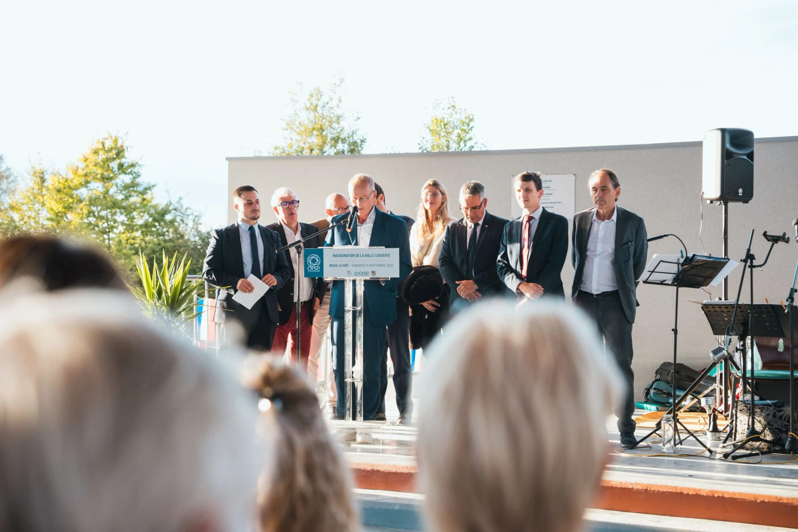 Les élus rangés derrière l'orateur pendant les discours d'inauguration, la plaque dévoilée visible sur le mur, mariage au Breuil-le-Vert (Oise), par Jean-Baptiste Argyre (Jaysphotography)