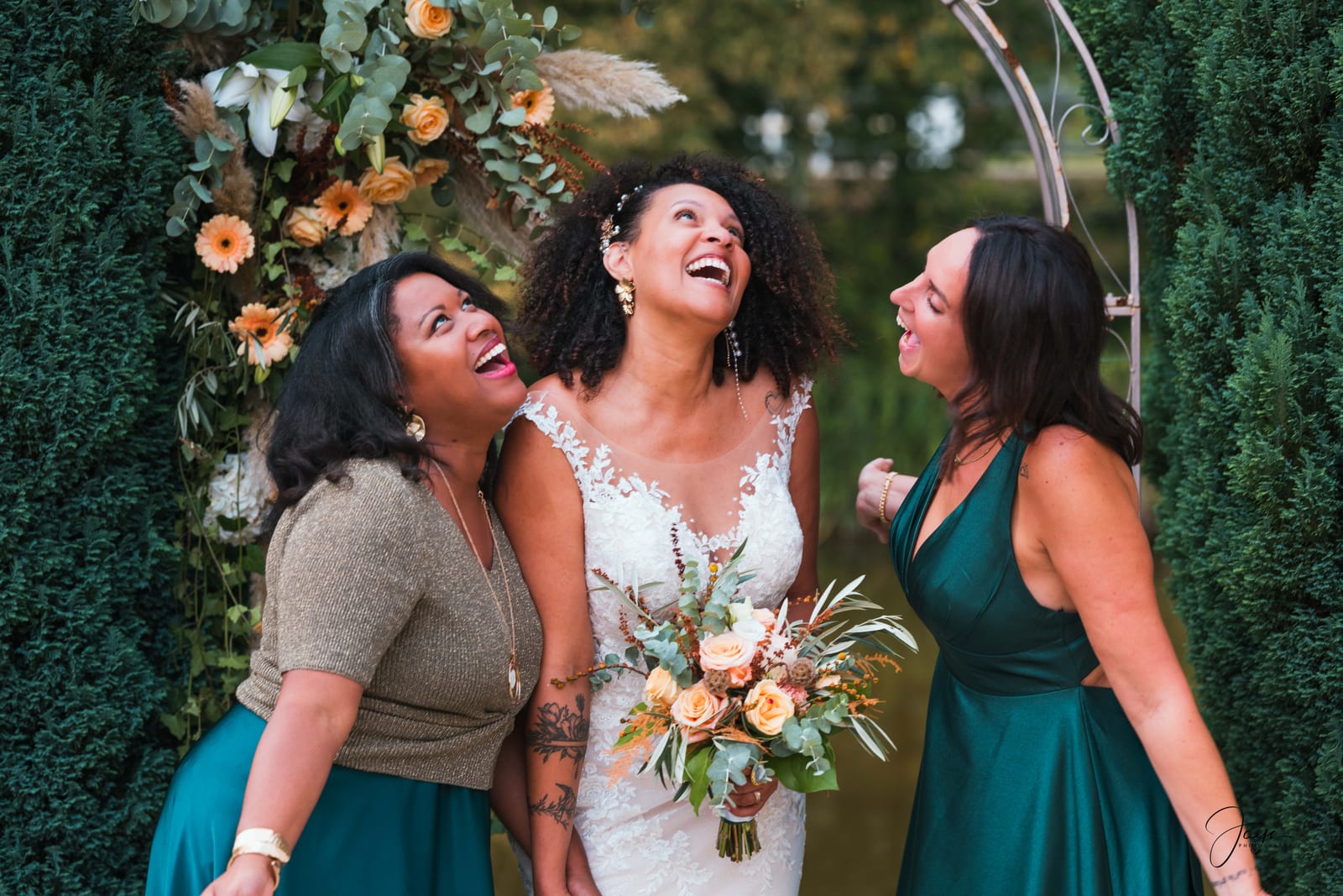 Jennifer et ses demoiselles d'honneur en vert bouteille, rires sous l'arche fleurie en topiaires, mariage au Château de Pontarmé, par Jean-Baptiste Argyre (Jaysphotography)