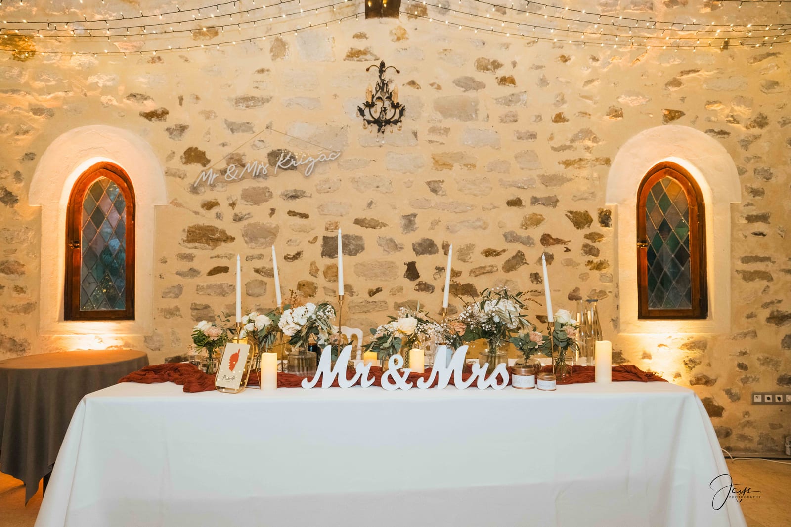 Table Mr and Mrs dans la salle en pierre, décoration florale et bougies blanches, mariage au Château de Pontarmé, par Jean-Baptiste Argyre (Jaysphotography)