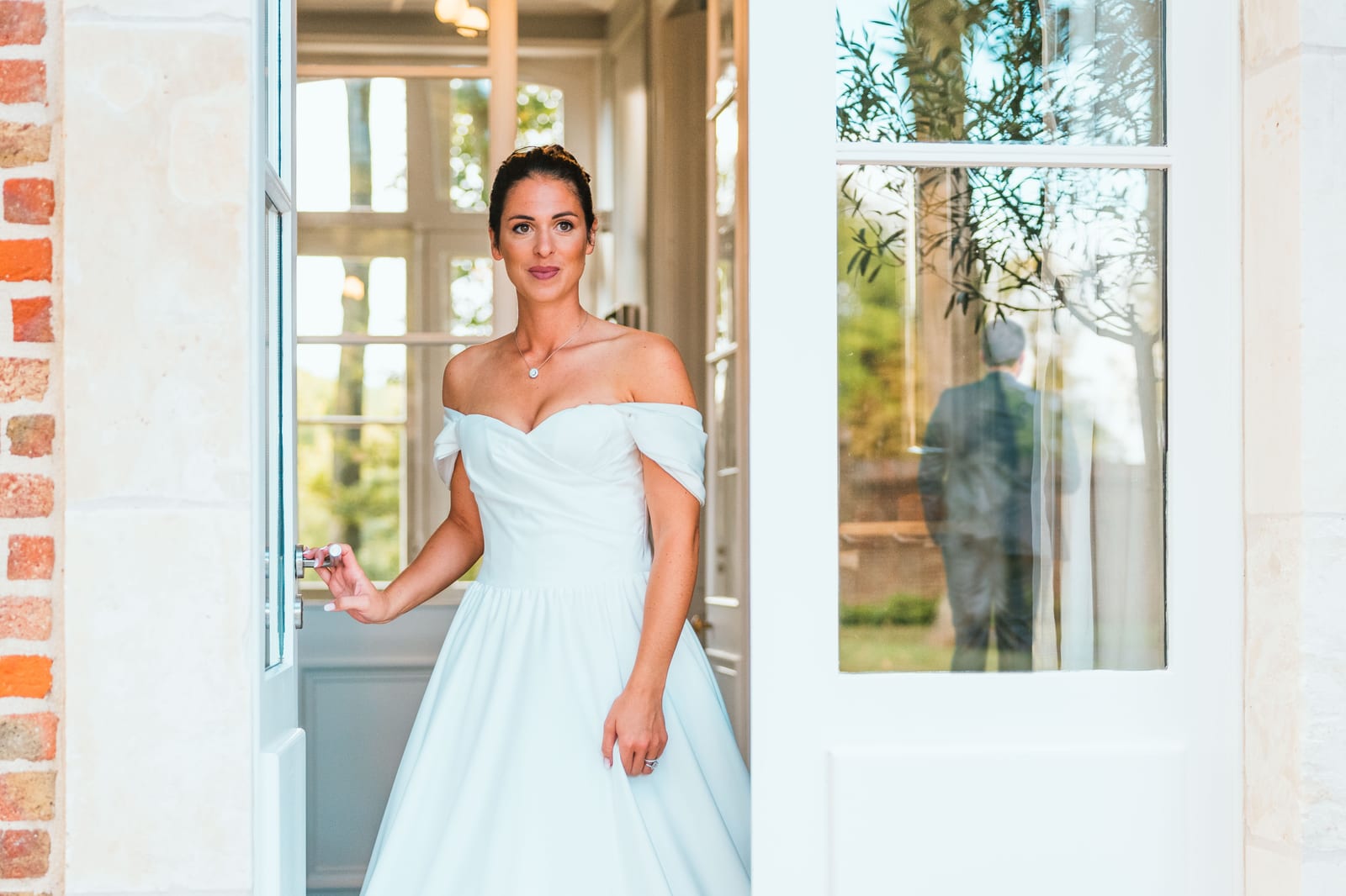 Joséphine en robe longue blanche décolletée épaules, portrait dans la lumière d'une fenêtre du château de Flixecourt, mariage au Château de Flixecourt, par Jean-Baptiste Argyre (Jaysphotography)