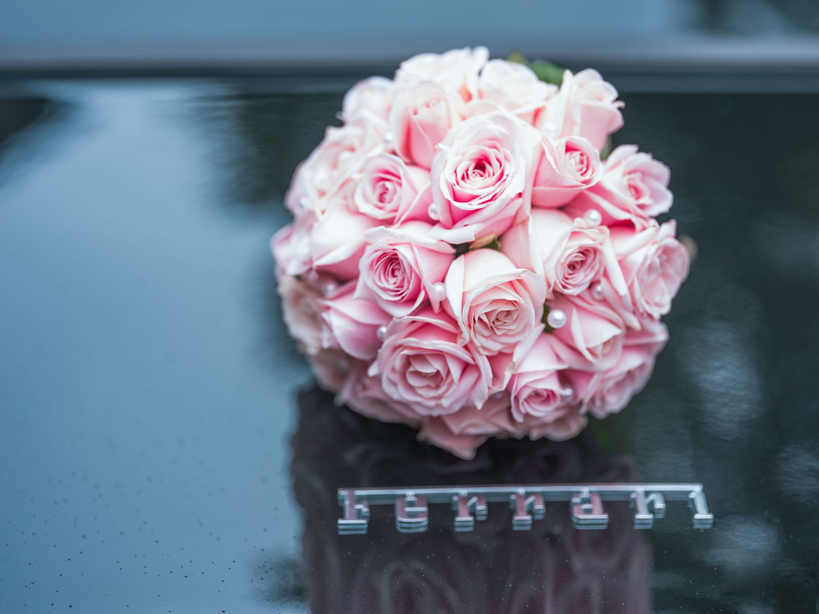Bouquet de roses roses posé sur un plan réfléchissant, lumière douce, mariage au Château de Flixecourt, par Jean-Baptiste Argyre (Jaysphotography)