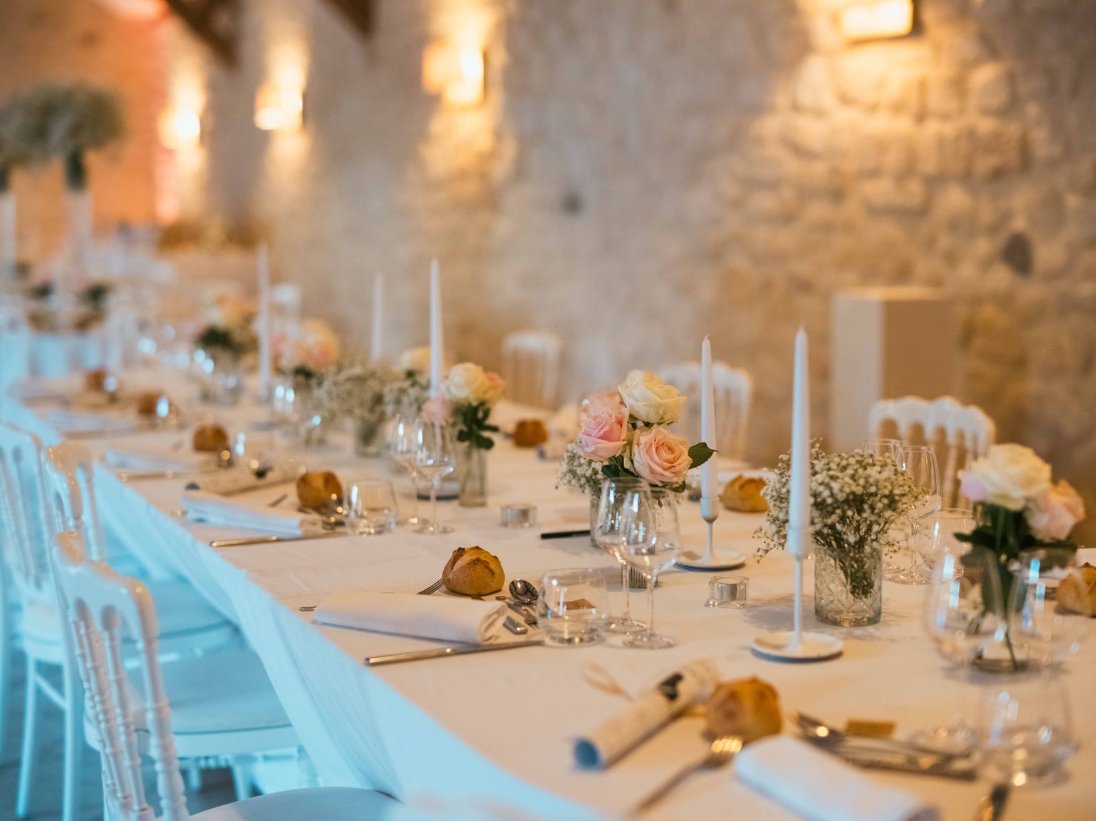 Salle de réception du Clos Barisseuse dressée, longue table avec guirlandes lumineuses et déco florale, mariage au Le Clos Barisseuse, par Jean-Baptiste Argyre (Jaysphotography)