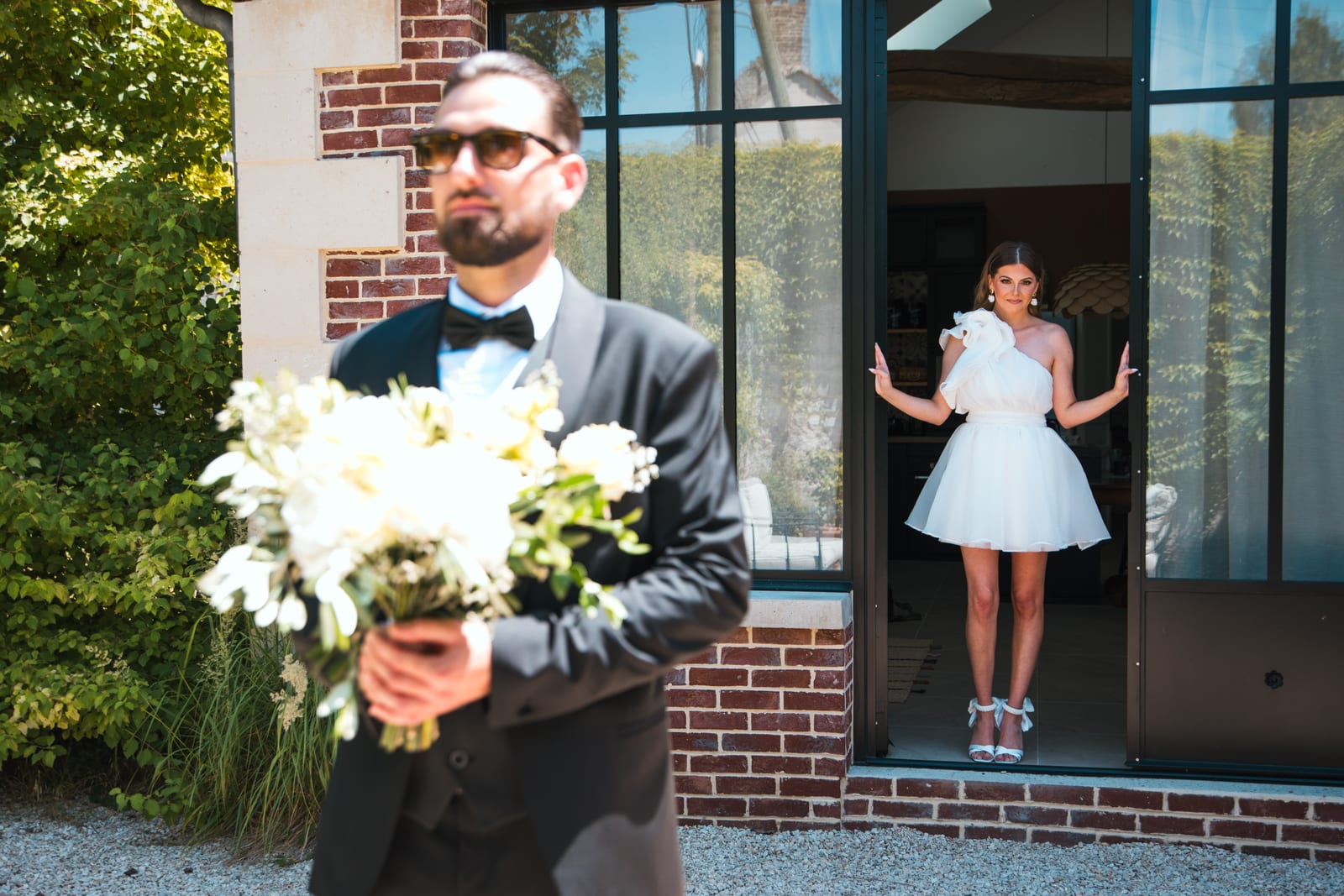 Killian en costume noir tenant le bouquet en extérieur, préparatifs au Domaine de l'Orangerie, mariage au Domaine de l'Orangerie, par Jean-Baptiste Argyre (Jaysphotography)