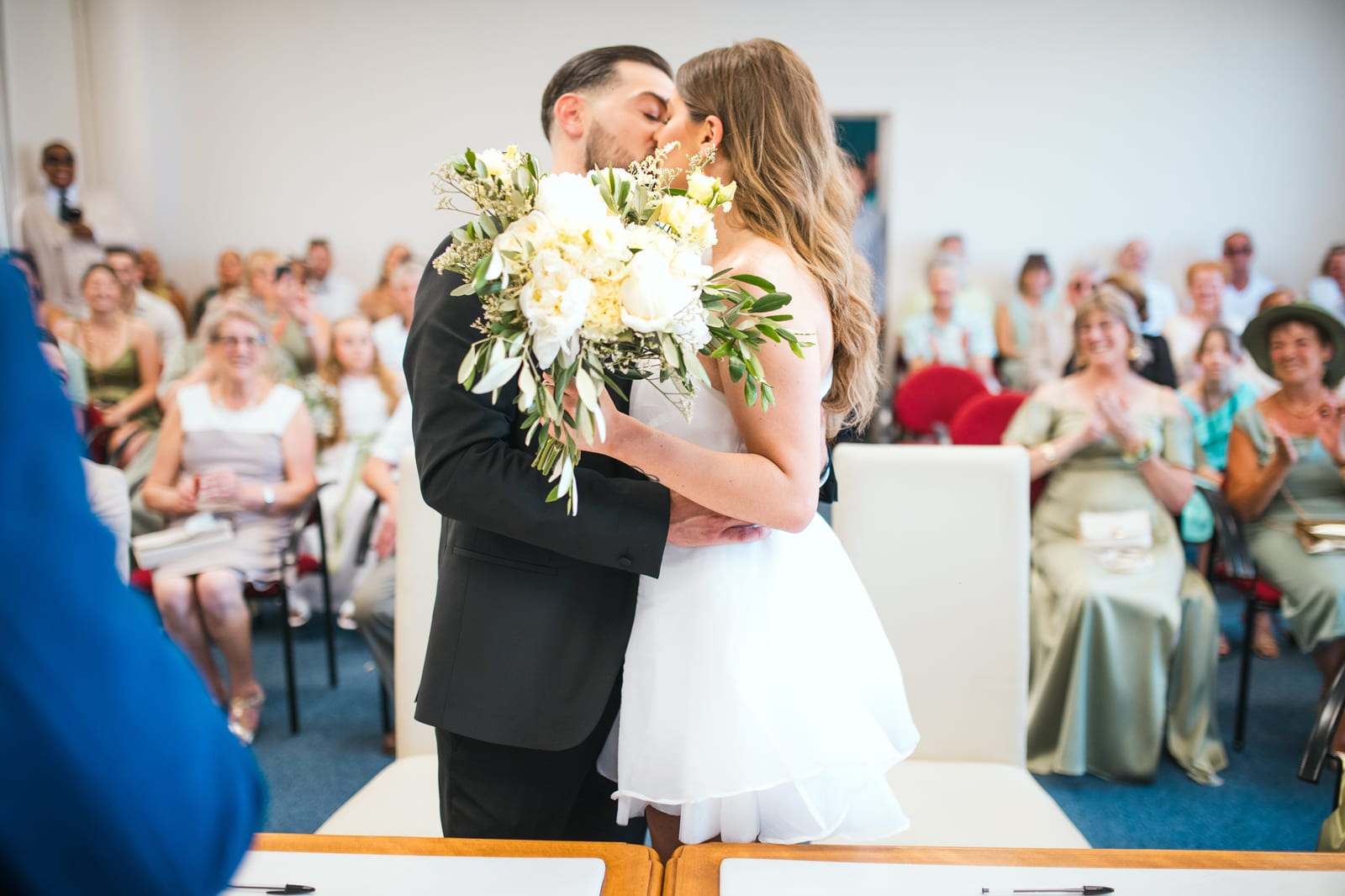 Killian et Élodie s'embrassent entourés de leurs invités assis, cérémonie laïque au Domaine de l'Orangerie, mariage au Domaine de l'Orangerie, par Jean-Baptiste Argyre (Jaysphotography)