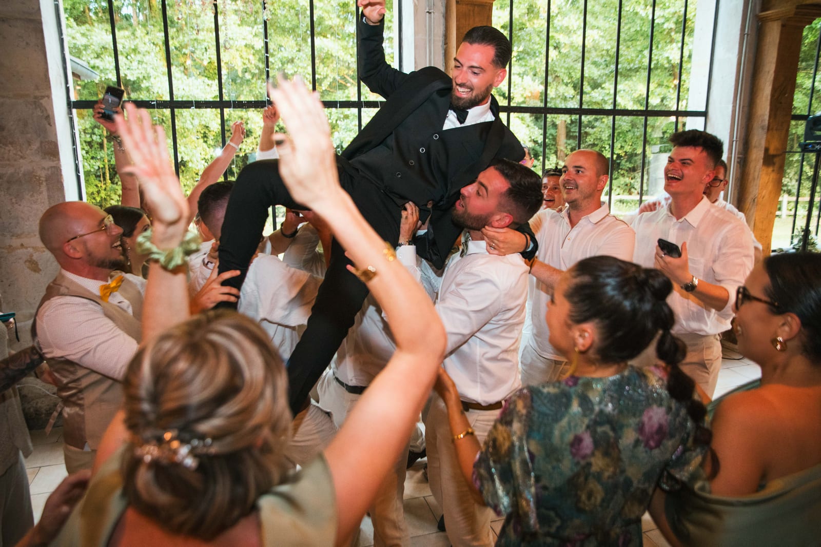 Invités en ambiance festive dans la salle en pierres apparentes du Domaine de l'Orangerie, mariage Killian et Élodie, mariage au Domaine de l'Orangerie, par Jean-Baptiste Argyre (Jaysphotography)