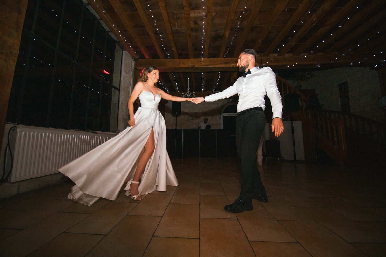 Première danse de Killian et Élodie dans la salle en pierre du Domaine de l'Orangerie, lumières de soirée, mariage au Domaine de l'Orangerie, par Jean-Baptiste Argyre (Jaysphotography)
