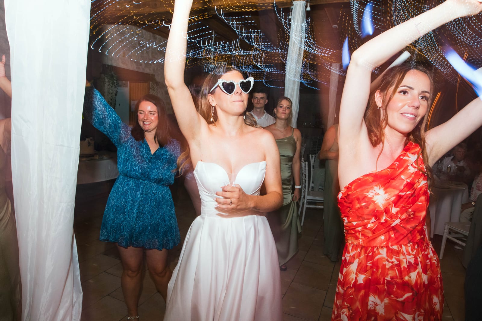 Invitées dansant avec lunettes de soleil et bras levés, soirée de mariage Killian et Élodie au Domaine de l'Orangerie, mariage au Domaine de l'Orangerie, par Jean-Baptiste Argyre (Jaysphotography)