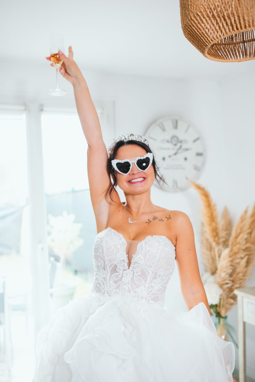 Laura levant une coupe de champagne avec des lunettes de soleil en cœur, ambiance festive au Domaine de la Croix Sauvalle, mariage au Domaine de la Croix Sauvalle, par Jean-Baptiste Argyre (Jaysphotography)