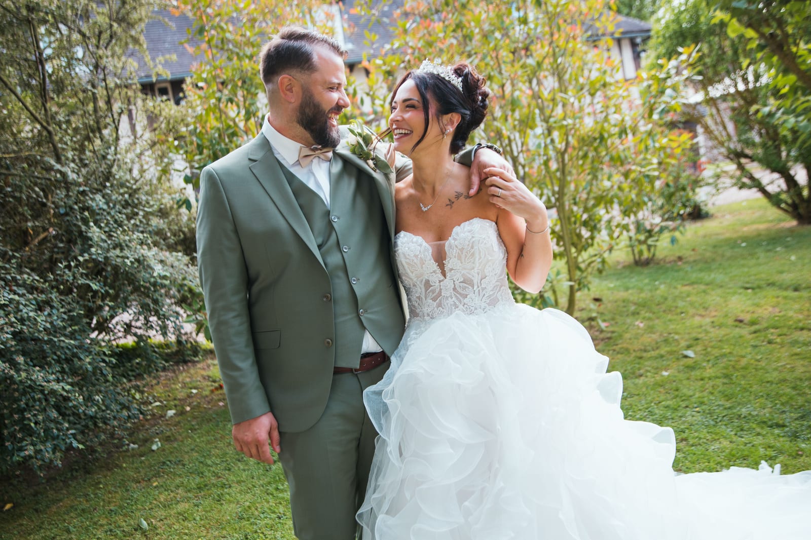 Laura et Sébastien complices et souriants dans le parc verdoyant, costume vert sauge et robe blanche, Domaine de la Croix Sauvalle, mariage au Domaine de la Croix Sauvalle, par Jean-Baptiste Argyre (Jaysphotography)