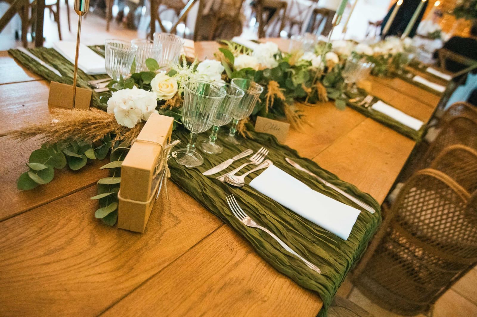 Décor de table de réception : chemin de table vert, roses blanches et pampas sur tables en bois, Domaine de la Croix Sauvalle, mariage au Domaine de la Croix Sauvalle, par Jean-Baptiste Argyre (Jaysphotography)