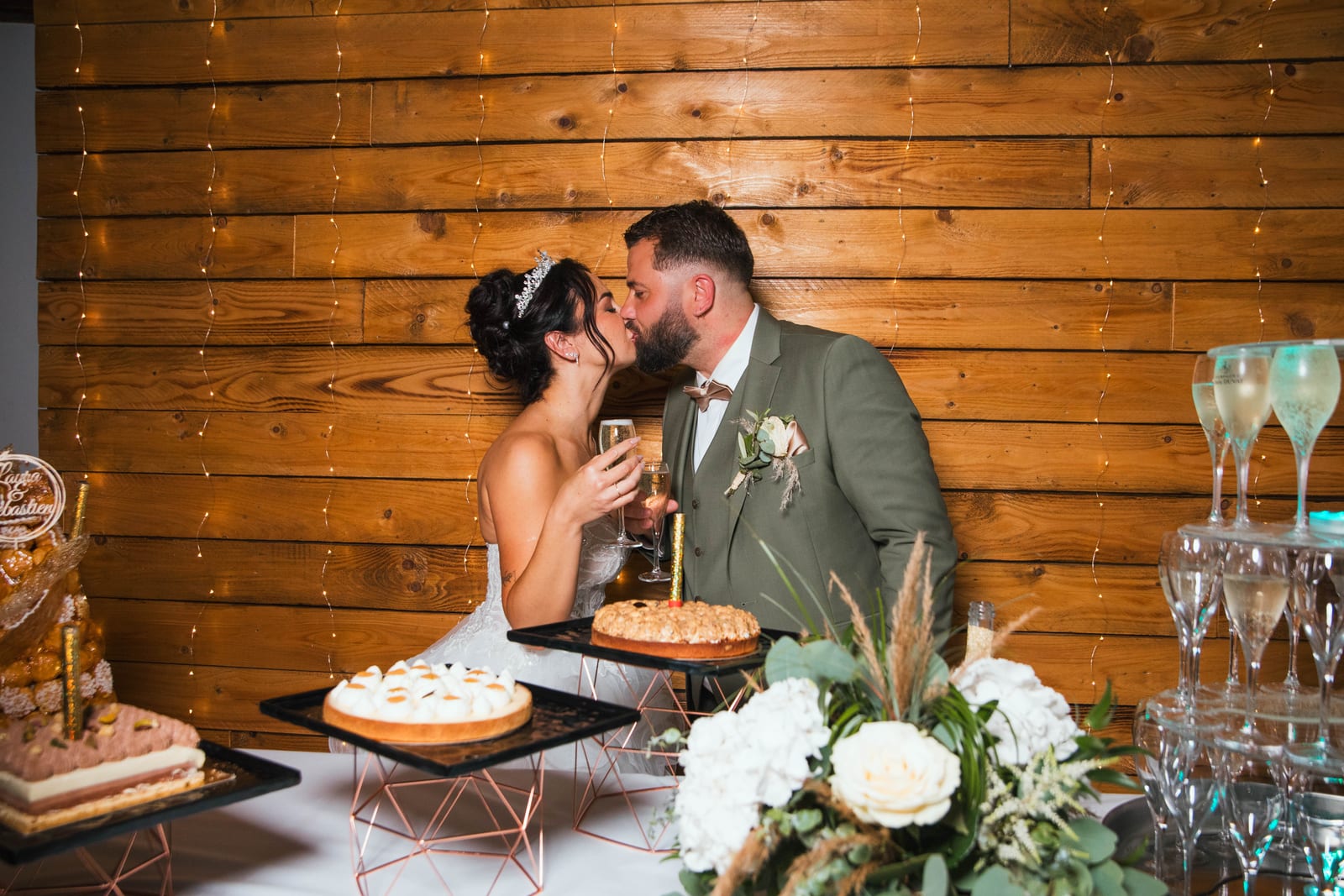 Laura et Sébastien s'embrassant devant le buffet de desserts et la pièce montée de coupes de champagne, Domaine de la Croix Sauvalle, mariage au Domaine de la Croix Sauvalle, par Jean-Baptiste Argyre (Jaysphotography)