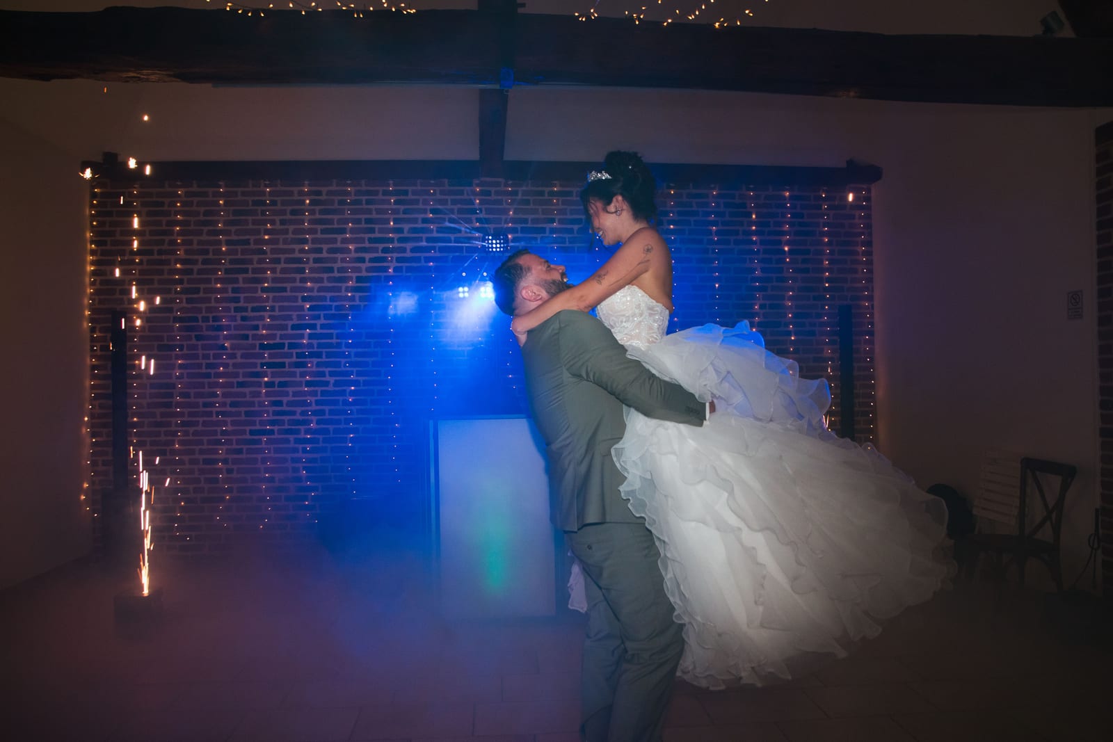 Sébastien soulevant Laura sous les étincelles et la lumière bleue de la soirée, Domaine de la Croix Sauvalle, mariage au Domaine de la Croix Sauvalle, par Jean-Baptiste Argyre (Jaysphotography)