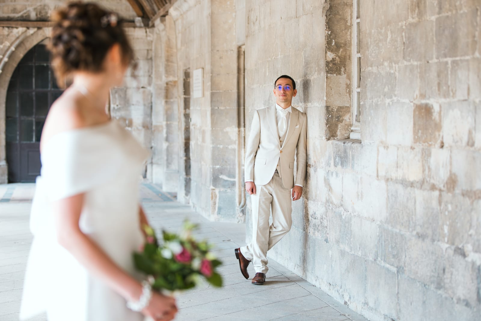 Lise marchant dans la galerie extérieure de l'abbaye, bouquet à la main, mariage au Abbaye Royale du Moncel, par Jean-Baptiste Argyre (Jaysphotography)