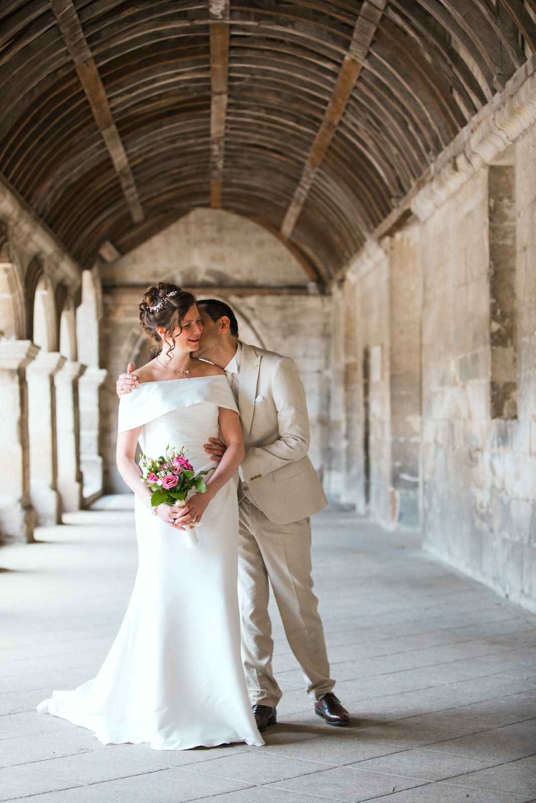 Lise et Alexandre enlacés sous la galerie voûtée en couloir, pierres médiévales, mariage au Abbaye Royale du Moncel, par Jean-Baptiste Argyre (Jaysphotography)