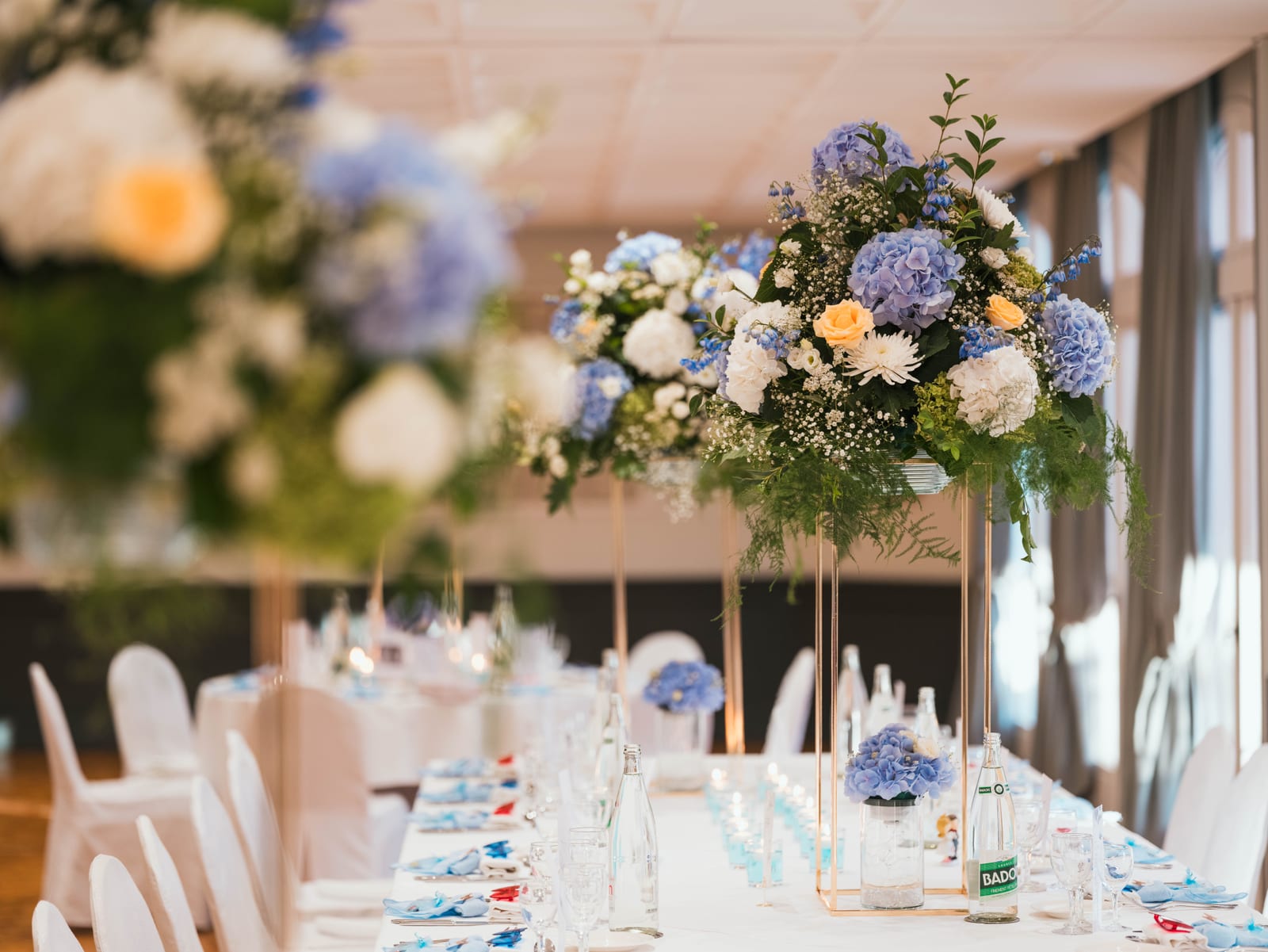 Détail d'un centre de table fleuri avec fleurs bleues et blanches, vaisselle et décorations du dîner de mariage, mariage au Château de La Tour, par Jean-Baptiste Argyre (Jaysphotography)