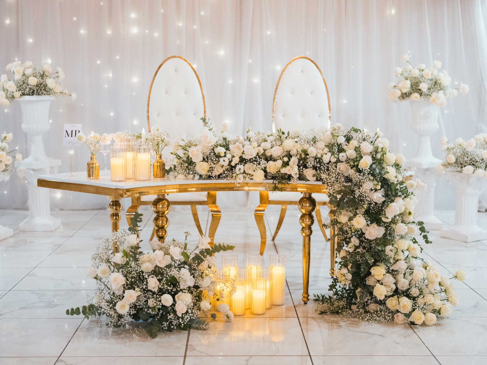 Table de cocktail avec arche fleurie et bougies, salle drapée en fond, mariage au Domaine de la Muette, par Jean-Baptiste Argyre (Jaysphotography)