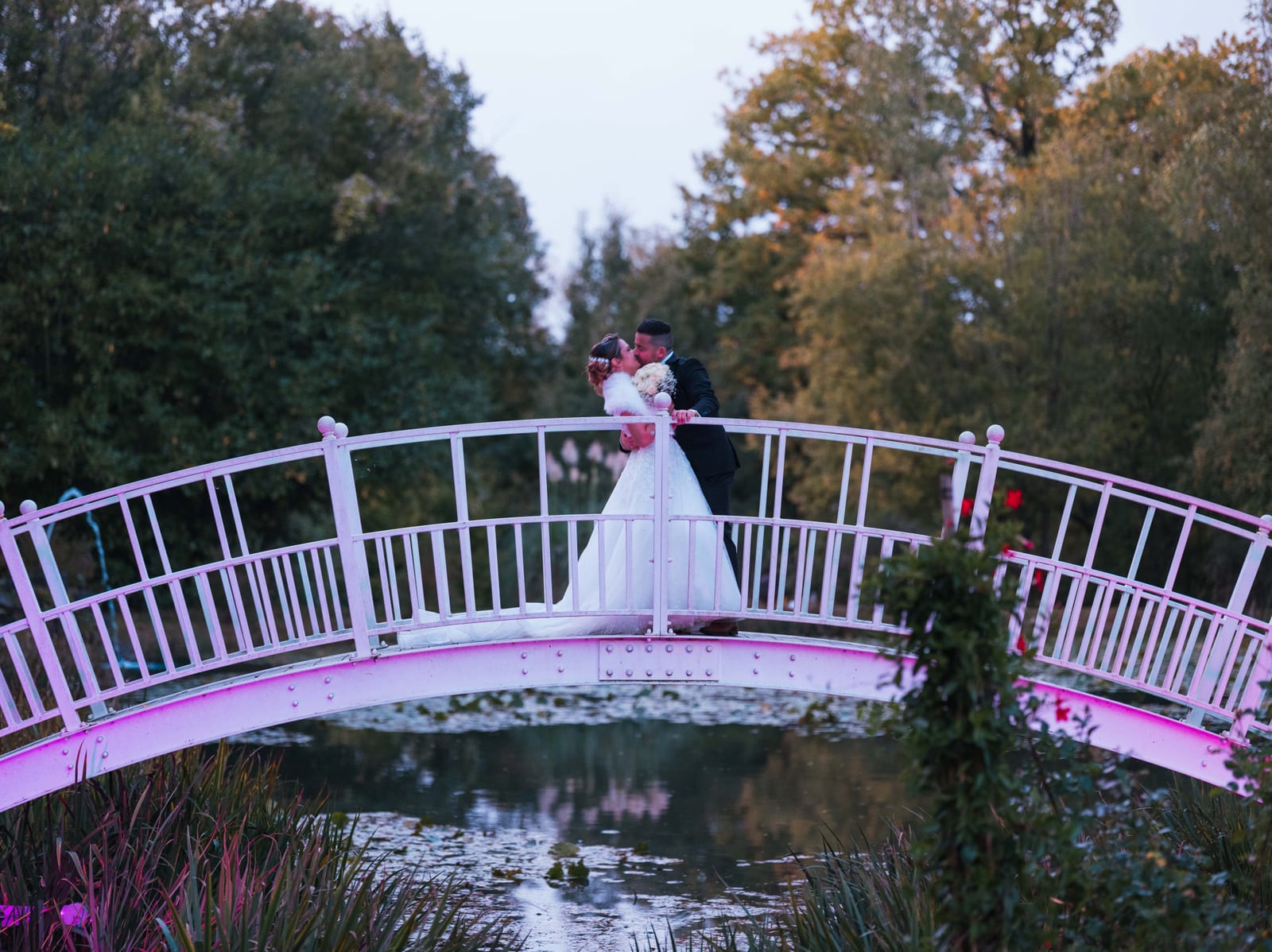 Manon sur le pont blanc emblématique du domaine, reflet dans l'eau, végétation automnale, mariage au Domaine de la Muette, par Jean-Baptiste Argyre (Jaysphotography)