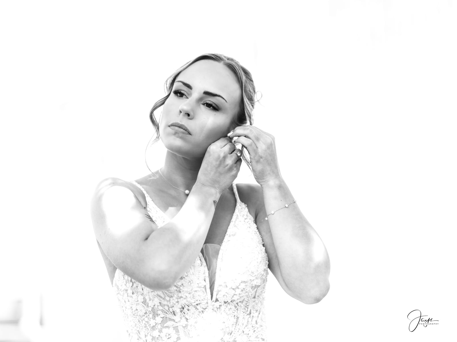 Manon en noir et blanc ajustant sa boucle d'oreille, portrait préparatifs de la mariée, mariage au Hippodrome de Chantilly, par Jean-Baptiste Argyre (Jaysphotography)