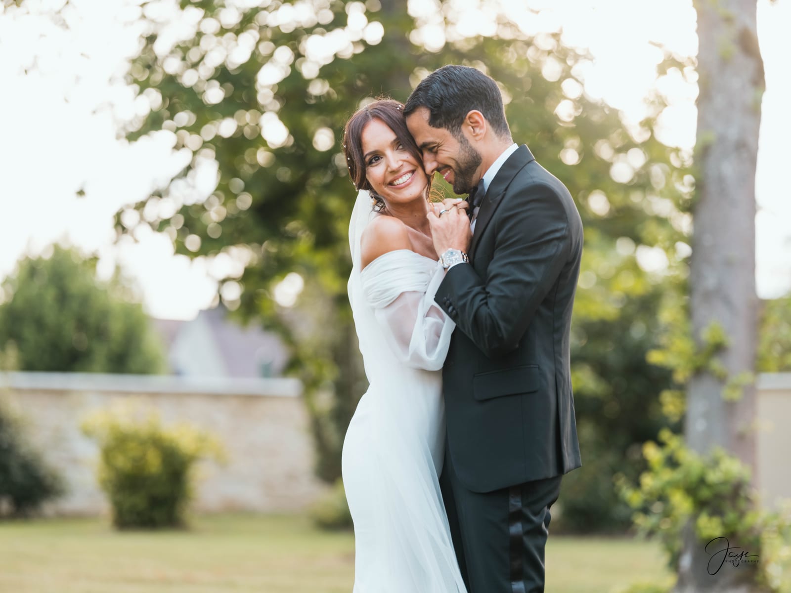 Margaux et Ayman sous les arbres en extérieur, marié tenant la mariée, lumière verte naturelle, Château d'Auvilliers, mariage au Château d'Auvilliers, par Jean-Baptiste Argyre (Jaysphotography)