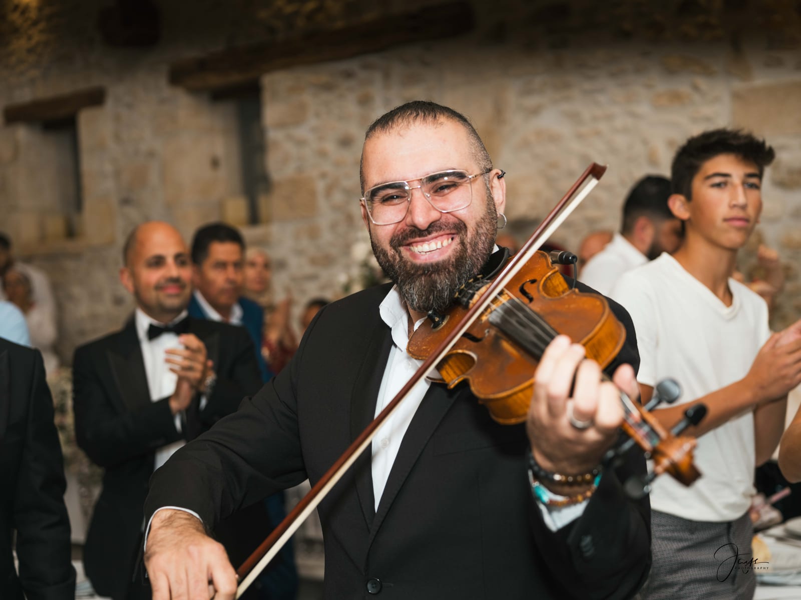 Violoniste en plein jeu pendant la soirée du mariage, invités en arrière-plan, Château d'Auvilliers, mariage au Château d'Auvilliers, par Jean-Baptiste Argyre (Jaysphotography)