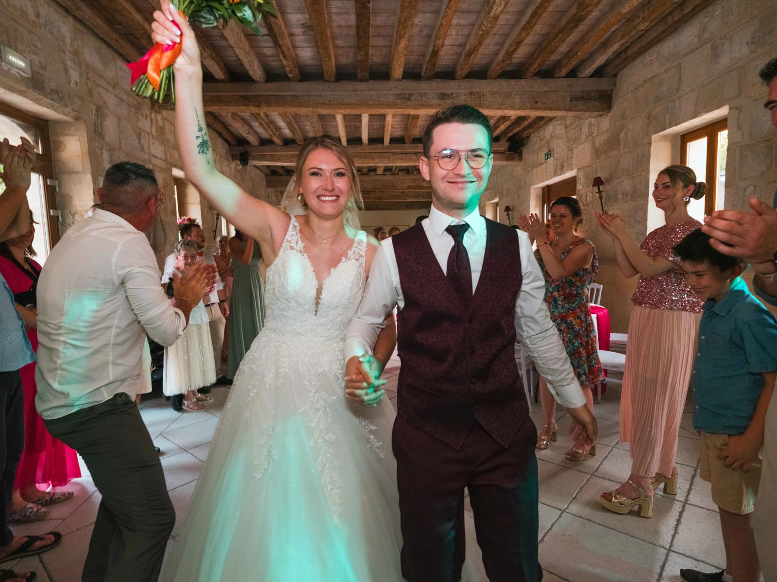 Alex et Audrey entrent dans la salle de réception bras levés, applaudis par les invités, mariage au Domaine du Bois Saint Mard, par Jean-Baptiste Argyre (Jaysphotography)