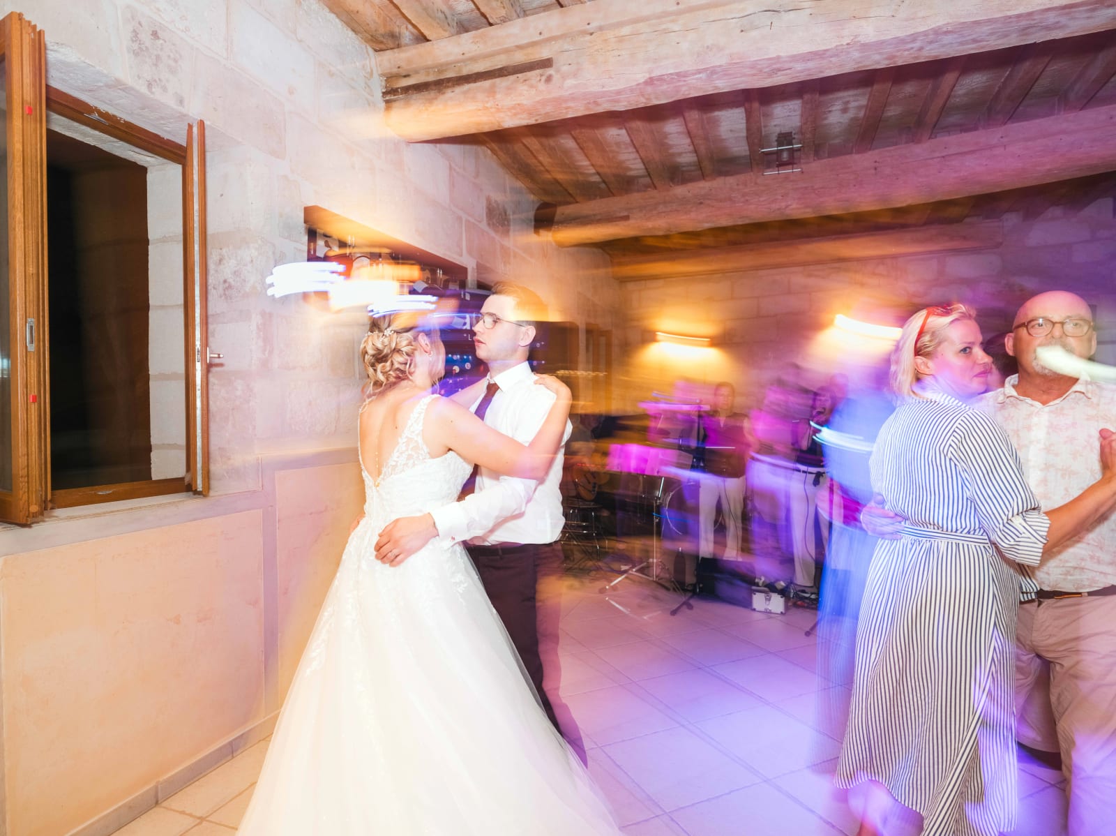 Première danse des mariés en pose longue, traînées de lumières violettes et dorées autour d'eux, mariage au Domaine du Bois Saint Mard, par Jean-Baptiste Argyre (Jaysphotography)