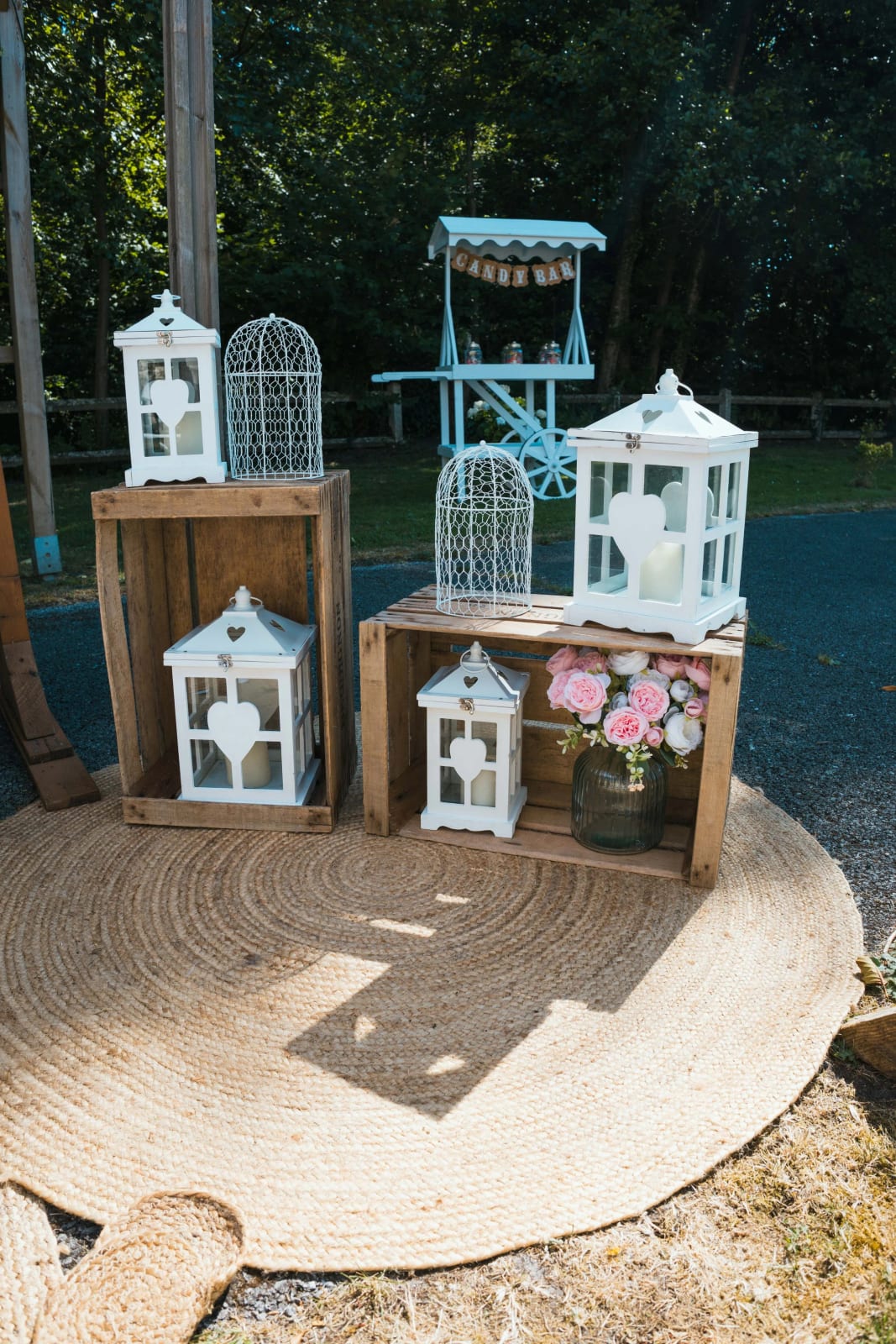 Décor champêtre du Domaine de l'Orangerie : lanternes blanches à cœurs, cagettes en bois, cages à oiseaux et chariot bleu ciel en bar à bonbons, mariage au Domaine de l'Orangerie, par Jean-Baptiste Argyre (Jaysphotography)