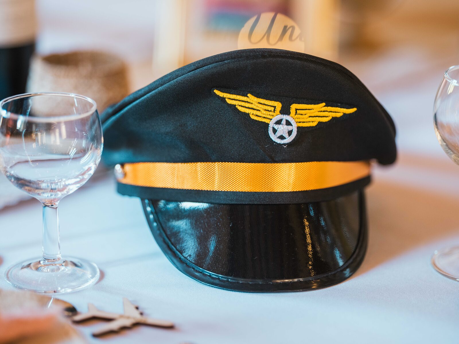 Détail de décoration de table sur le thème de l'aviation : une casquette de commandant de bord — mariage au Domaine du Bois Saint Mard, par Jean-Baptiste Argyre (Jaysphotography)