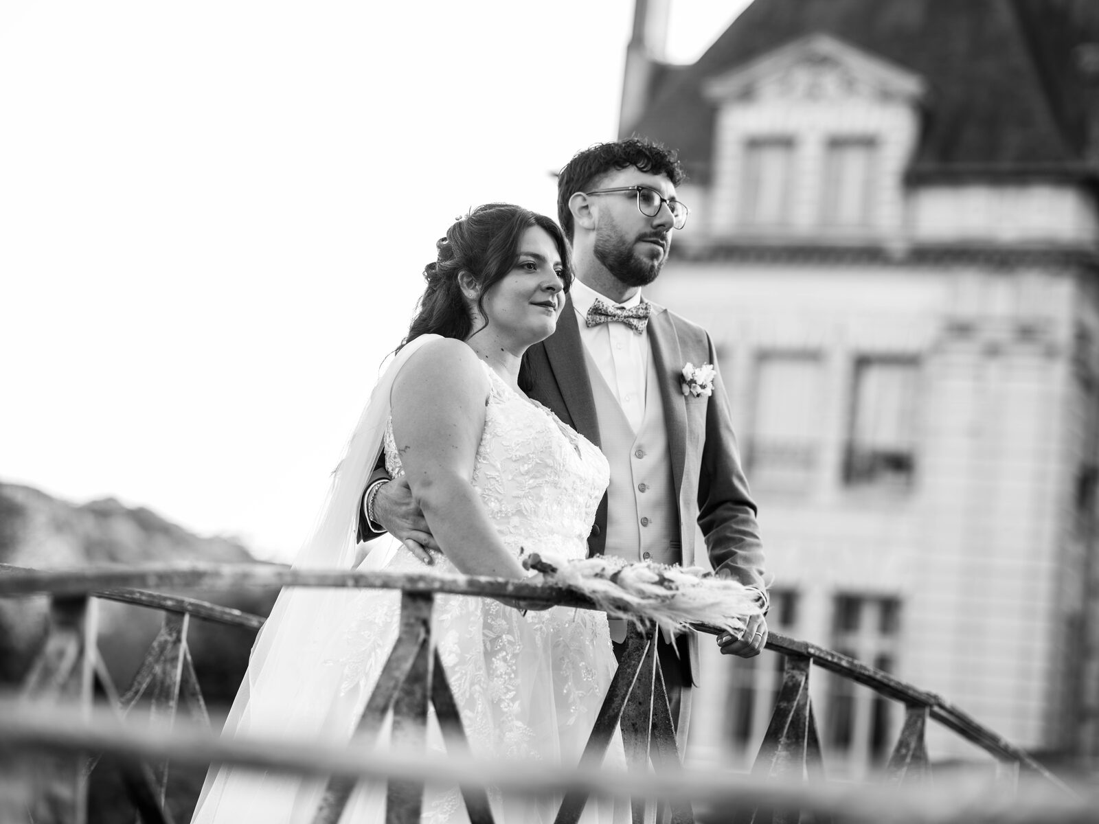 Portrait noir et blanc du couple sur le petit pont, le château du domaine en arrière-plan — mariage au Domaine du Bois Saint Mard, par Jean-Baptiste Argyre (Jaysphotography)