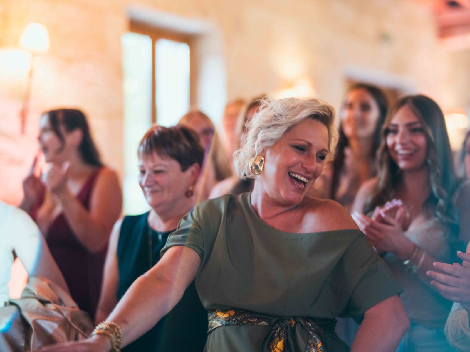 Une invitée en robe kaki danse et rit au milieu de la fête — mariage au Domaine du Bois Saint Mard, par Jean-Baptiste Argyre (Jaysphotography)