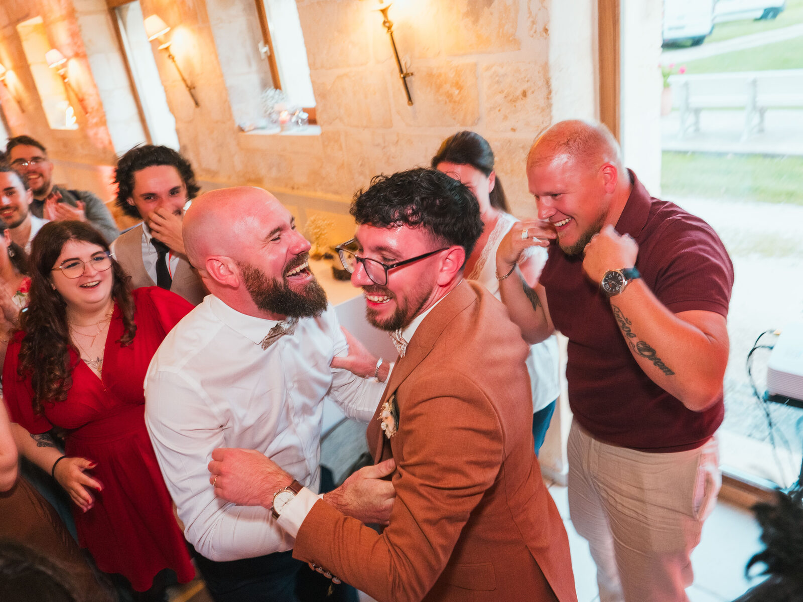 Le marié enlacé en riant par deux amis pendant la soirée — mariage au Domaine du Bois Saint Mard, par Jean-Baptiste Argyre (Jaysphotography)