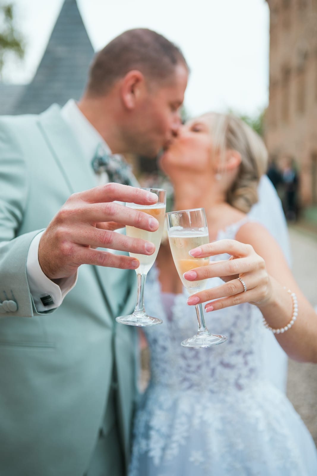 Amandine et Benjamin s'embrassent en trinquant au champagne pendant le vin d'honneur au domaine, mariage au Domaine de Senercy, par Jean-Baptiste Argyre (Jaysphotography)