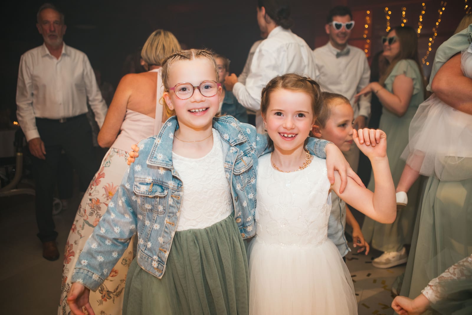 Deux enfants d'honneur sourient face à l'objectif sur la piste de danse pendant la fête, mariage au Domaine de Senercy, par Jean-Baptiste Argyre (Jaysphotography)