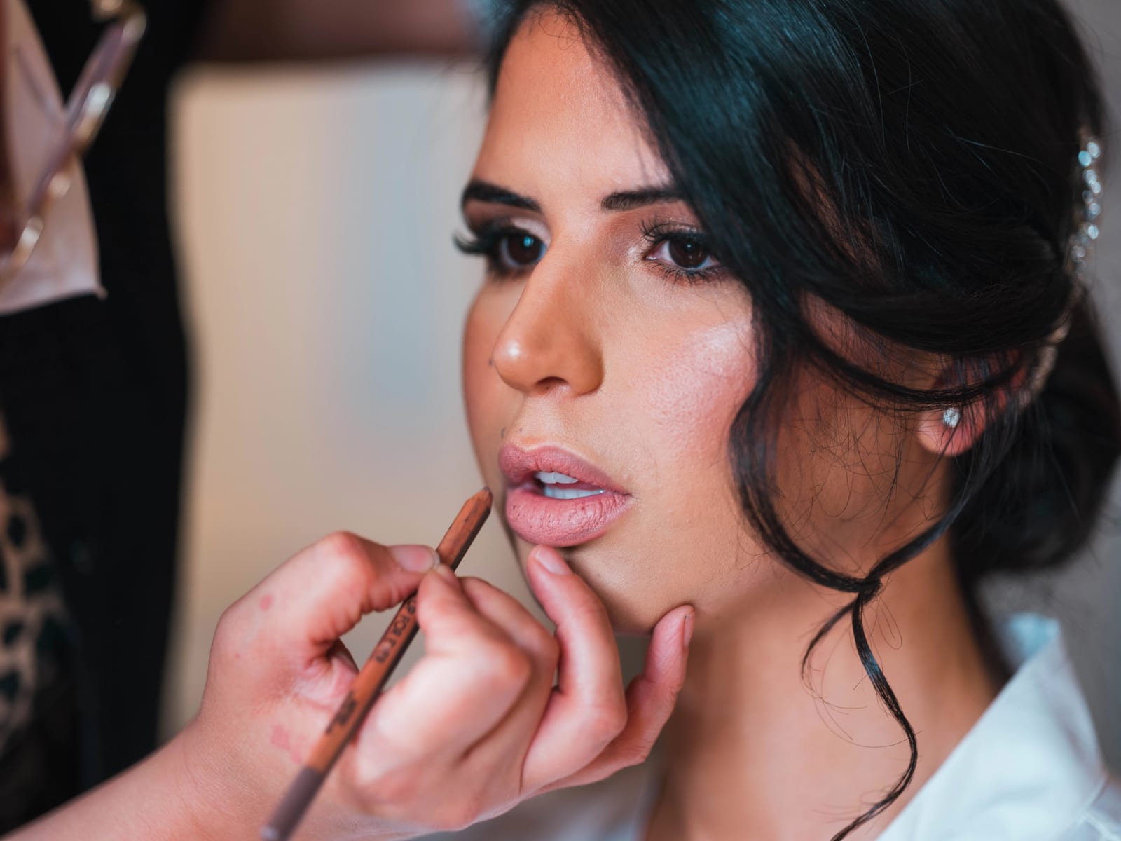Mise en beauté de la mariée : on trace le contour de ses lèvres au crayon, chignon bas et peigne de strass, mariage au Château de Montvillargenne, Gouvieux, par Jean-Baptiste Argyre (Jaysphotography)