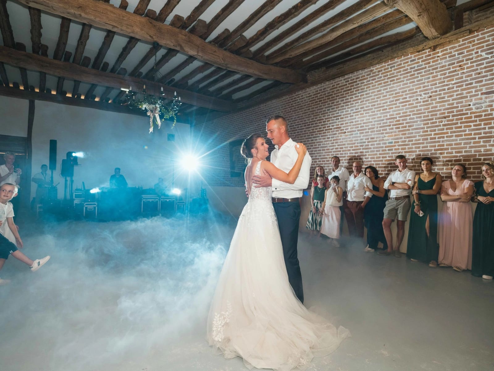 La première danse d'Amélie et Guillaume dans une nappe de fumée qui couvre le sol de la salle, mariage au Les Voûtes du Plessier, par Jean-Baptiste Argyre (Jaysphotography)