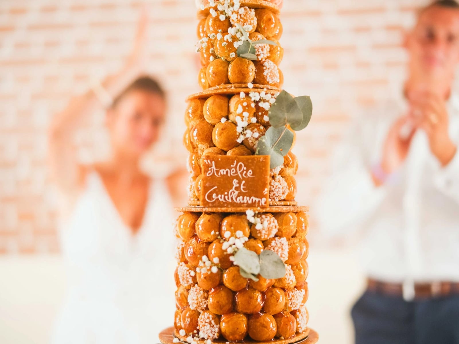 La pièce montée de choux portant les prénoms d'Amélie et Guillaume, décorée de fleurs blanches, mariage au Les Voûtes du Plessier, par Jean-Baptiste Argyre (Jaysphotography)