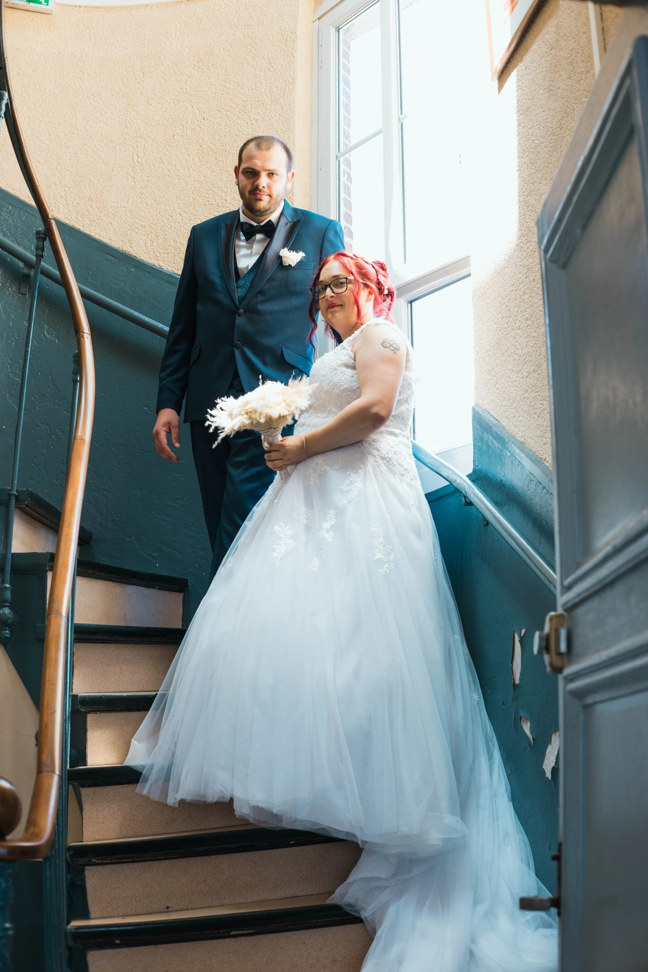 Angélique et Antoine dans l'escalier avant la cérémonie, robe et bouquet de pampa, costume bleu, mariage au Buironfosse (Aisne), par Jean-Baptiste Argyre (Jaysphotography)